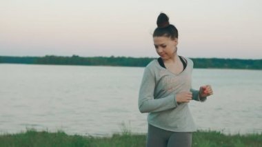 Isınma-up sabah yoga pratik yapmak için genç kızı. Yeşil çimen, göl. Yaz günü