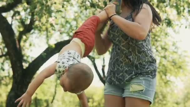 Young mother with her little two year old boy playing outdoors with love — Stock Video