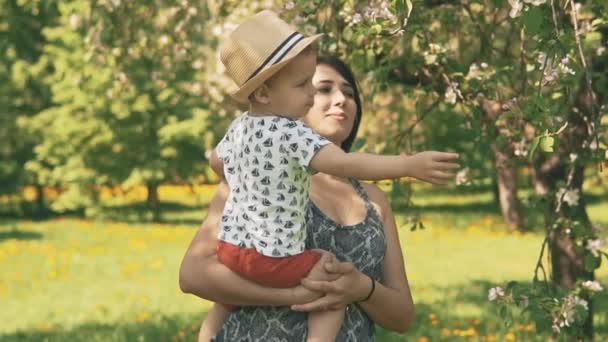 Молодая мать со своим очаровательным мальчиком играет на свежем воздухе с любовью — стоковое видео