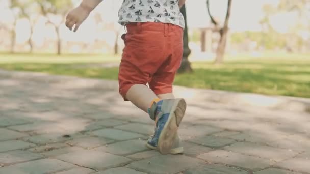 Μικρό αγόρι τρέχει έξω. Αργή κίνηση του παιδιού που τρέχει στο πάρκο — Αρχείο Βίντεο
