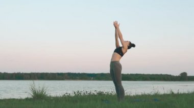 Güneş doğarken yoga yaparken kadın. Yoga, spor ve sağlıklı yaşam konsepti