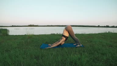 Güzel genç kadın mavi yoga mat sessiz sahne gündoğumu, yoga yaparken