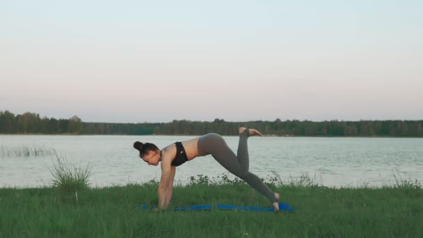 Mujer haciendo yoga en un paisaje tranquilo. Yoga, deporte y estilo de vida saludable — Vídeos de Stock