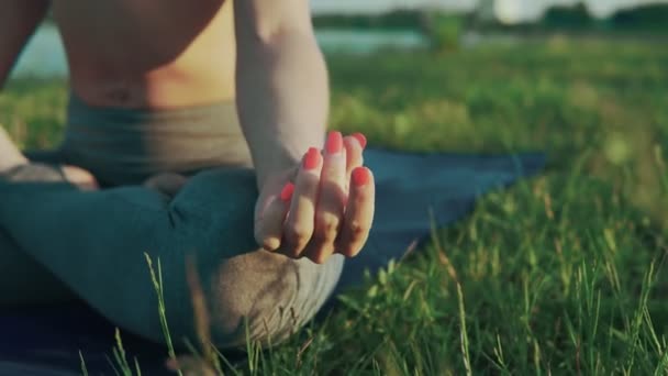 Mädchen macht morgens Yoga am See. Hände einer Frau in Lotusstellung bei Sonnenaufgang — Stockvideo