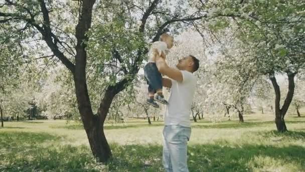 Padre e figlio che giocano al parco. Papà alleva il bambino tra le braccia e vomita — Video Stock