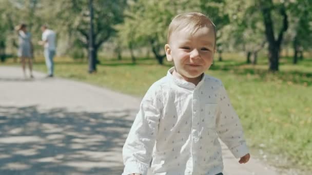 Liten pojke kör från sina föräldrar. Lycklig familj i slow motion — Stockvideo