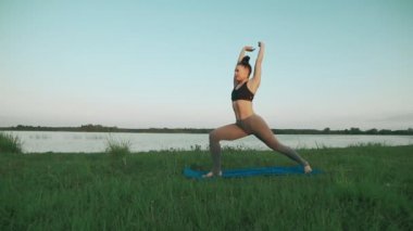 Güzel genç kadın mavi yoga mat sessiz sahne sabah yoga yaparken