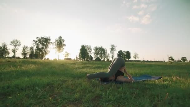 Krásná dívka cvičí jógu v ranní parku. Bruneta žena dělá jógu — Stock video