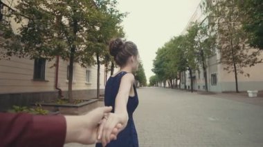 Genç çift eller kadın önde gelen erkek sokakta yürürken holding