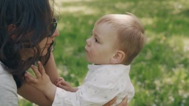 Genç Anne ve oğlu açık havada güneş gözlüğü ile oynuyor. Annelik kavramı