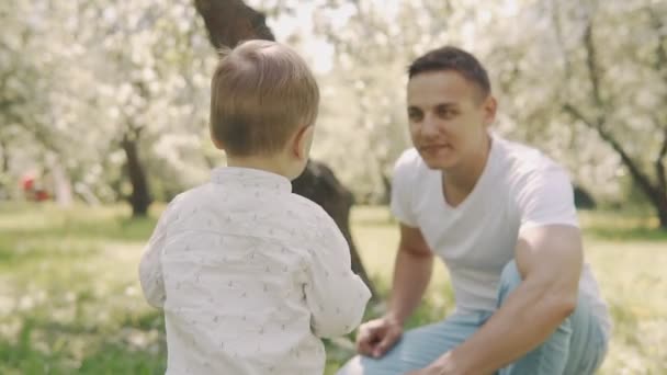 Concepto de paternidad. Padre joven e hijo pequeño se divierten al aire libre en cámara lenta — Vídeos de Stock