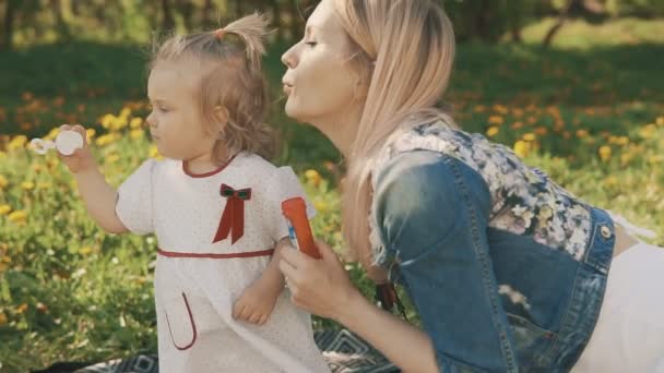 Mor och dotter spelar tillsammans, blåser bubblor. Mamma och barn — Stockvideo