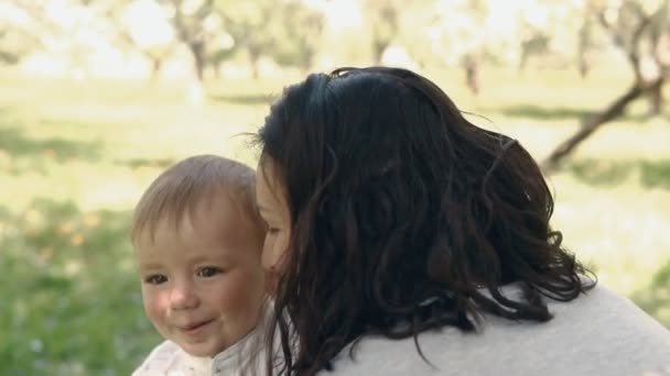 Η μαμά δείχνει αγάπη και στοργή στο γιο. Νεαρή μητέρα και γιο να παίζουν σε εξωτερικούς χώρους — Αρχείο Βίντεο
