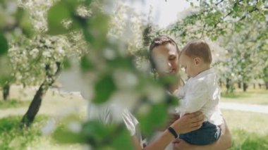 Beyaz ebeveynler yaz elma ağacı Park sevimli oğlu gidiyor gülümseyen