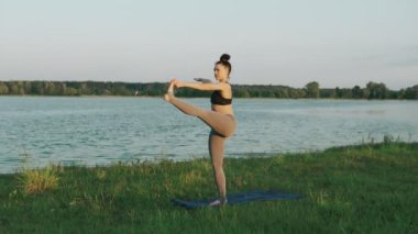 Güzel bir kadın sabah Yoga uygulamak. Yoga yaparken kız yeşil çimenlerin üzerinde hareket eder.