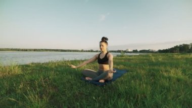 Güzel bir kadın sabah Yoga uygulamak. Yoga yaparken kız yeşil çimenlerin üzerinde hareket eder.