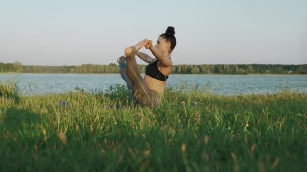 Hermosa chica practicando yoga en el parque matutino. Mujer morena haciendo yoga — Vídeos de Stock