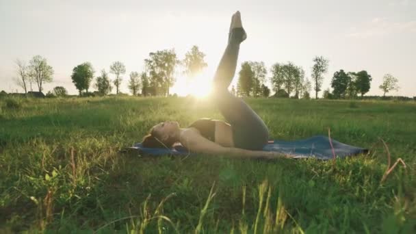 Belle fille pratiquant le yoga dans le parc du matin. Femme brune faisant du yoga — Video