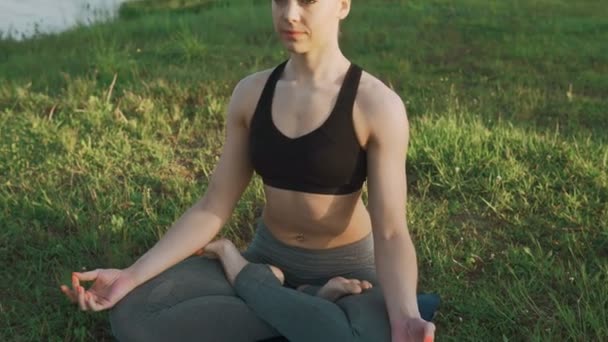 Ung flicka gör yoga i morgon vid sjön. Hälsosam livsstil och yoga koncept — Stockvideo