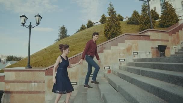 Um lindo casal a subir para a direita. Sorrindo menino e menina se movendo ao ar livre — Vídeo de Stock