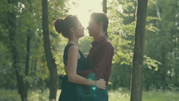 Fiatal szerelmespár átölelve a parkban. Naplemente boldog emberek portré — Stock videók