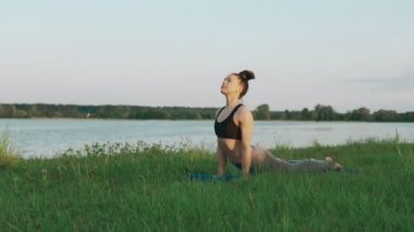 Güzel genç kadın mavi yoga mat sessiz sahne sabah yoga yaparken