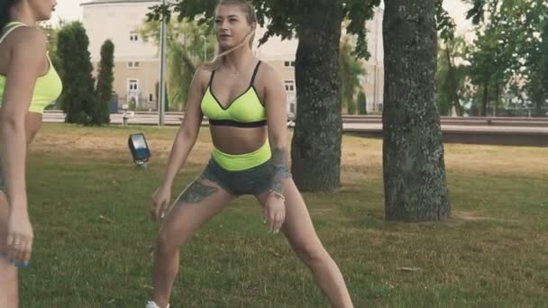 Fitness deportivo. Chicas de gimnasia calentando estirando al aire libre. Estilo de vida saludable — Vídeos de Stock