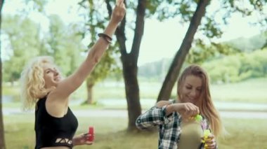 Beauiful hipster kızlar eğleniyor güneş gözlüğü ile baloncuklar park yapma