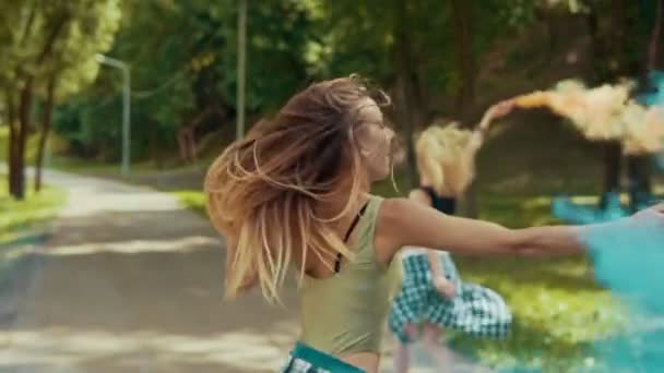 Mooie hipster meisjes loopt in park zwaaien gekleurde rook. Jonge meisjes veel plezier — Stockvideo