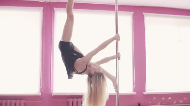 Female poledance woman splitting her legs while hanging on pole — Stock Video