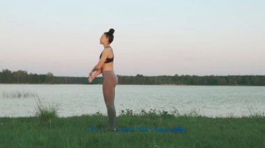 Güzel genç kadın mavi yoga mat sessiz sahne sabah yoga yaparken