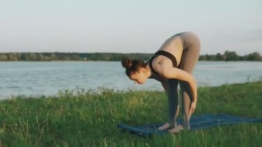 Pratik yoga sabah parkta güzel bir kız. Esmer kadın yoga yaparken