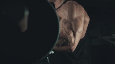 Pazı egzersiz halter ağır çekimde karanlık jimnastik salonu ile yaparak vücut geliştirmeci