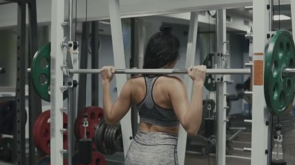 Hermosa mujer deportiva en ropa deportiva haciendo ejercicio en cuclillas en el gimnasio en cámara lenta — Vídeo de stock