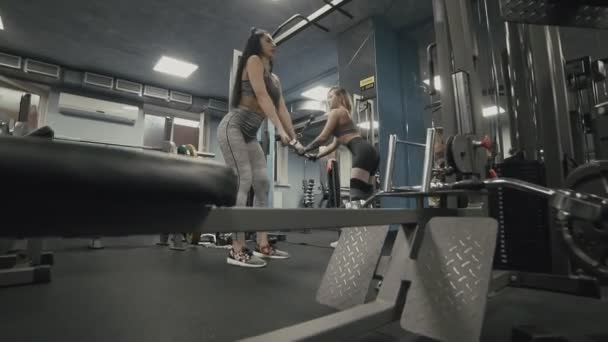 Meisjes doen oefening op terug spieren in blok simulator in slow motion — Stockvideo