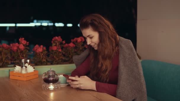 Женщина с помощью приложения на смартфоне в кафе и SMS на мобильном телефоне с копирайтом — стоковое видео