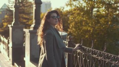 Sevimli genç kadın güneş gözlüğü sonbahar slomo kat şehirde size yürür