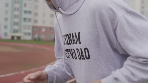Young man running in hoodie outdoors. Boxer training at stadium in morning — Stock Footage Young man running in hoodie outdoors. Boxer training at stadium in morning Royalty Free Stock Footage