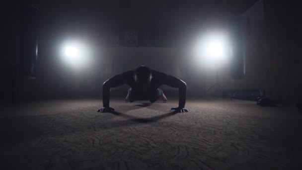 Μπόξερ κάνει push-ups στο σκοτεινό καπνιστή γυμναστήριο. Σιλουέτα του αθλητή σε σκούρο φόντο — Αρχείο Βίντεο