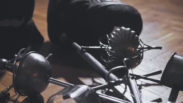 Close-up of swords and masks for fencing on floor — Stock Video