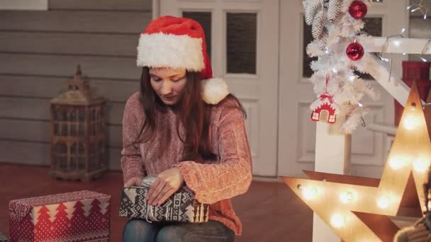 Szép nő, a karácsonyi kalap, ajándék csomagolás bemutatja — Stock videók