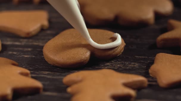 Décoration de biscuits de Noël. Gros plan garniture maison coeur de pain d'épice — Video