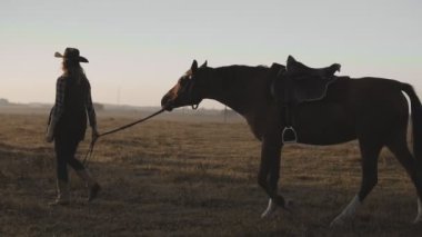 Yürüyüşte karanlık güzel atı dizginleri tarafından sunrise alarak genç kız.