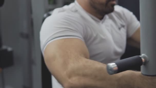 Aufklappen eines Bodybuilders bei Übungen im Simulator im Fitnessstudio für Brustmuskeln — Stockvideo