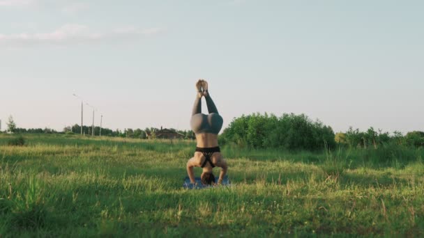 Vacker flicka gör yoga utomhus vid soluppgången. Fitness girl utbildning i morgon — Stockvideo