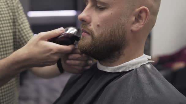 Barber holení vousů s elektrický holicí strojek a hřeben salon. Holič zastřihování vousů — Stock video