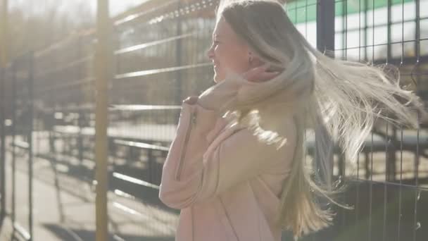 Aantrekkelijk meisje glimlacht camera buiten kijken. Lachende blonde vrouw bij zonsondergang — Stockvideo