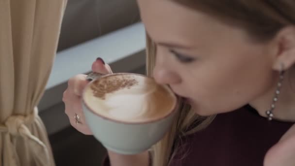 Menina atraente cheirando o aroma de café e relaxando no café . — Vídeo de Stock