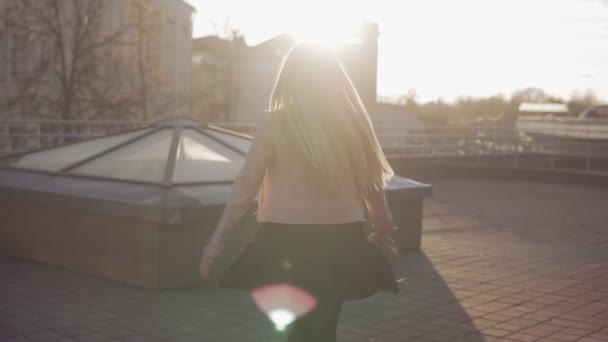 Retrato de una mujer bonita con el pelo largo sonriendo en la ciudad al amanecer o al atardecer — Vídeo de stock