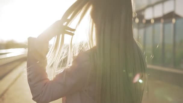 Piękna Blondynka kobieta uśmiecha się do kamery i odwracając o zachodzie słońca — Wideo stockowe